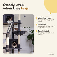 Cats in the dark gray cat tree with a wide base