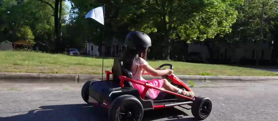 Girl driving the kart slowly along the curb